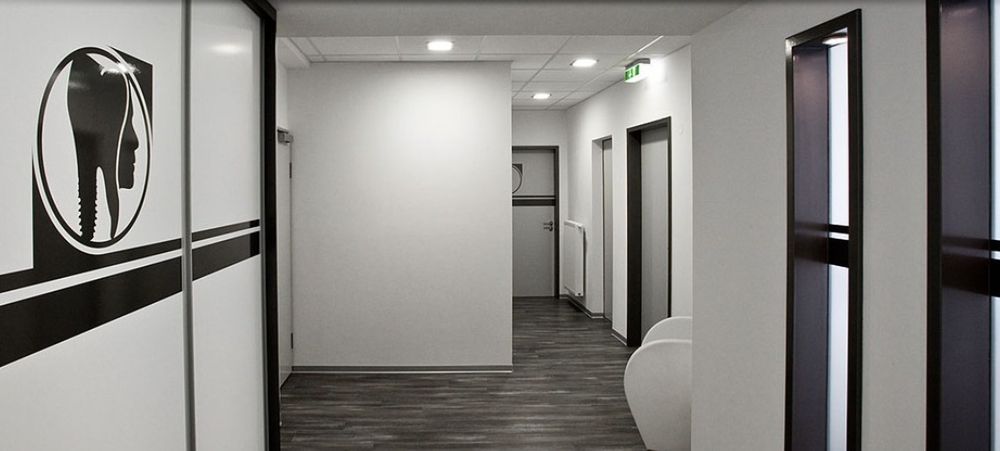 Glastür mit Praxislogo und Blick in den Flur